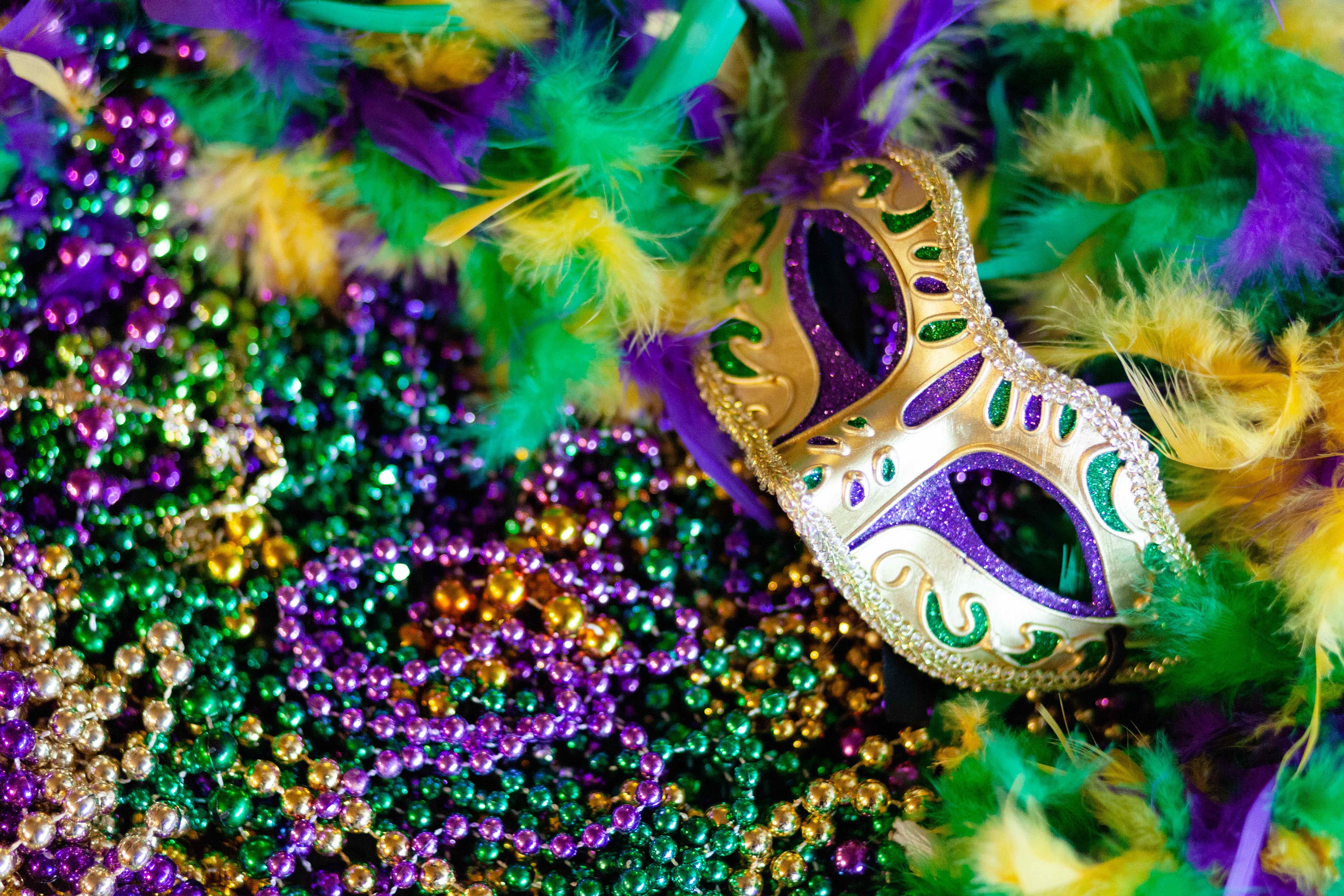 mardi gras beads with mask and feathers